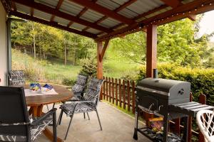 a patio with a grill and a table and chairs at Dzika Stokrotka in Idzików