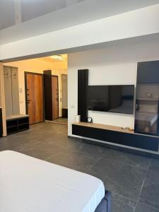 a bedroom with a bed and a flat screen tv at Luxury & Spacious Studio - Navodari in Năvodari