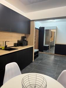 a kitchen with black cabinets and a table and chairs at Luxury & Spacious Studio - Navodari in Năvodari