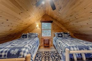 a bedroom with two beds in a log cabin at The Pinecone in Winthrop