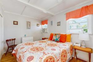 a bedroom with a bed with orange pillows and a window at Lil in York