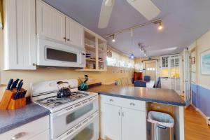 a kitchen with a stove and a microwave at The Cottage at Long Sands in York