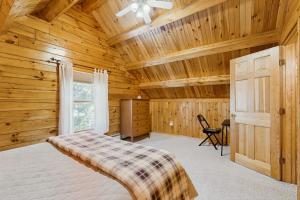 a bedroom with a bed in a wooden cabin at Moose Cabin in Bridgton