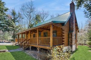 a log cabin with a porch and a chimney at Moose Cabin in Bridgton