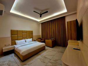 a hotel room with a bed and a ceiling fan at Hotel Satyaki Orchid in Katra
