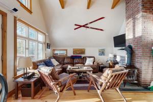 a living room with a couch and a clock on the wall at Mullen Chalet in Greenwood