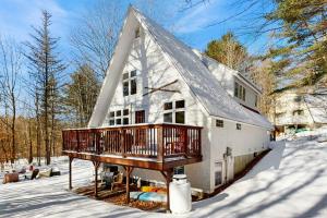 a large white house with a deck in the snow at Mullen Chalet in Greenwood