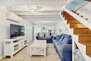 a living room with a blue couch and a tv at Long Sands Serenity in York