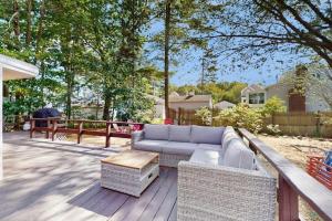a patio with a couch and wicker furniture on a deck at Long Sands Serenity in York