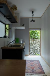 a kitchen with a sink and a large window at 青梅駅3分OME桜梅庵omean tinyhouse designers hideaway in Ome
