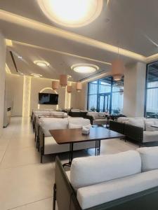 a large room with couches and tables and a television at Ammar Hotel in Dushanbe