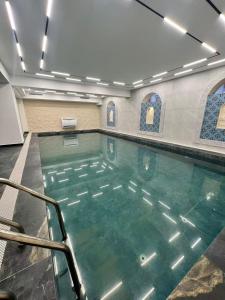 a swimming pool with green water in a building at Ammar Hotel in Dushanbe
