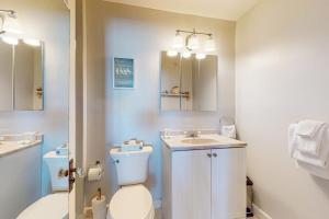 a bathroom with a toilet and a sink and a mirror at The Lookout #210 in Ogunquit +43 photos