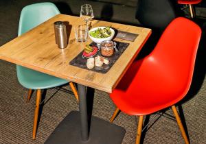 a table with a plate of food and a glass of wine at ibis Cambrai in Cambrai