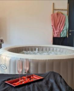 two champagne glasses on a table in front of a bed at La maison du soleil in Vitrolles