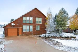 a wooden house with a garage in the snow at Kick Back Cabin in Pagosa Springs