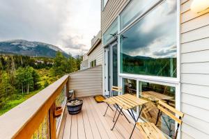 a balcony with a wooden table and chairs on it at Watch Hill Lofted in Silverthorne
