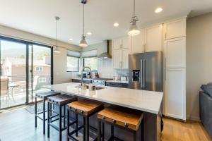 a kitchen with a large island with bar stools at Woodhaven Hideaway in Frisco