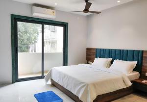 a bedroom with a bed and a large window at Stay by Insata Hospitality - Kolkata in Kolkata