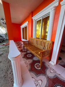 a wooden bench sitting on the porch of a house at Tellos Beach House in Siquijor