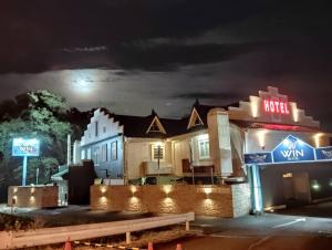 a motel sign in front of a building at night at Hotel WIN in Fukaya