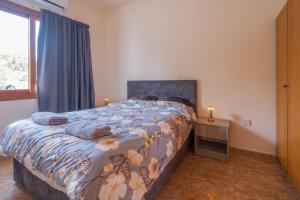 a bedroom with a large bed and a window at Sunset Sea View Retreat with pool in Kissonerga