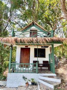 a small white house with a thatch roof at Benny Seaview house in Ao Phutsa
