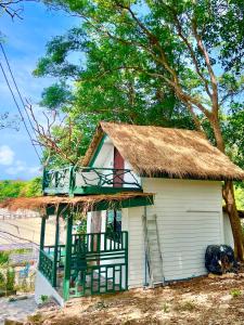 a small white house with a thatch roof at Benny Seaview house in Ao Phutsa