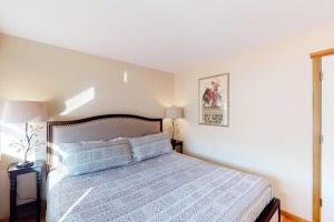 a bedroom with a bed with a blue comforter at Jarvis #202 in Durango
