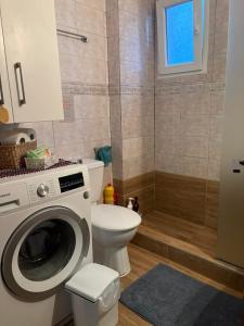 a bathroom with a washing machine and a toilet at Aithra House Αίθρα in Toroni +54 photos