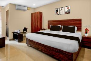 a bedroom with a large bed in a room at Hotel O Benz Circle Crossway Vijayawada Formerly Akshaya Elite in Vijayawada +24 photos