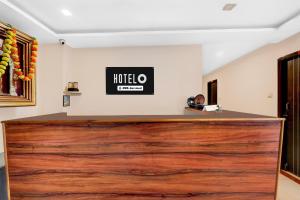 a reception desk with a large wooden door at Hotel O Benz Circle Crossway Vijayawada Formerly Akshaya Elite in Vijayawada