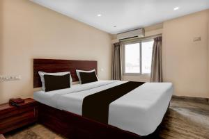 a large bed in a bedroom with a window at Hotel O Benz Circle Crossway Vijayawada Formerly Akshaya Elite in Vijayawada
