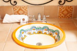 a sink in a bathroom with a plate on it at Hotel Dainzu in Oaxaca City +32 photos