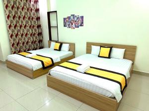 two beds in a hotel room withskirts at 158A Hotel in Ho Chi Minh City