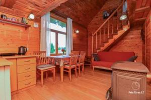 a dining room with a table and chairs in a cabin at Viesu māja "Ozoliņi" in Jūrkalne +28 photos
