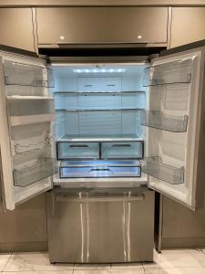 an empty refrigerator with its doors open in a kitchen at The Boho - 4 min walk to beach & town in Bournemouth