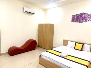 a bedroom with a bed and a red chair at 158A Hotel in Ho Chi Minh City