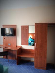 a bedroom with a bed and a desk with a mirror at Hotel - Restaurant Braustube in Haaren