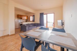 a dining room with a table and chairs and a kitchen at Sunset Sea View Retreat with pool in Kissonerga