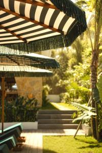 a patio with a black and white umbrella and stairs at Kanalla Boutique Hotel - Adults Only in Kuta Lombok