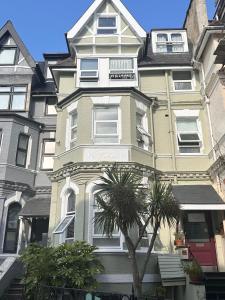 a tall building with a palm tree in front of it at The Boho - 4 min walk to beach & town in Bournemouth