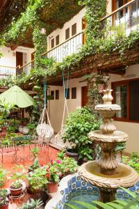 a fountain in the middle of a courtyard with plants at Hotel Dainzu in Oaxaca City