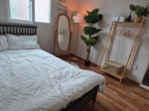 a bedroom with a bed and a large mirror at 스미다 stay in Bucheon