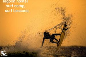 a man riding a wave on a surfboard in the ocean at Lagoon Hostel in Arugam Bay