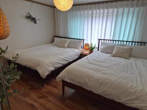 a bedroom with two beds and a window at 스미다 stay in Bucheon