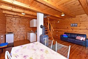 a dining room with a table and a stove in a cabin at Ežero Panorama in Skirlėnai
