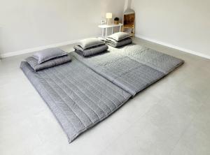 a large gray bed with pillows on a floor at SiSu2 in Chilgok