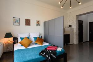 a bedroom with a bed with blue and yellow pillows at Студія біля Університету in Chernivtsi