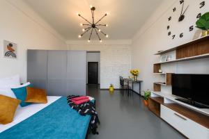 a bedroom with a large bed and a large clock on the wall at Студія біля Університету in Chernivtsi